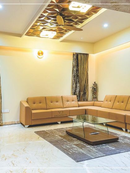 Another view of the living room with the geometric ceiling detail, showing the spacious layout and warm, inviting lighting.