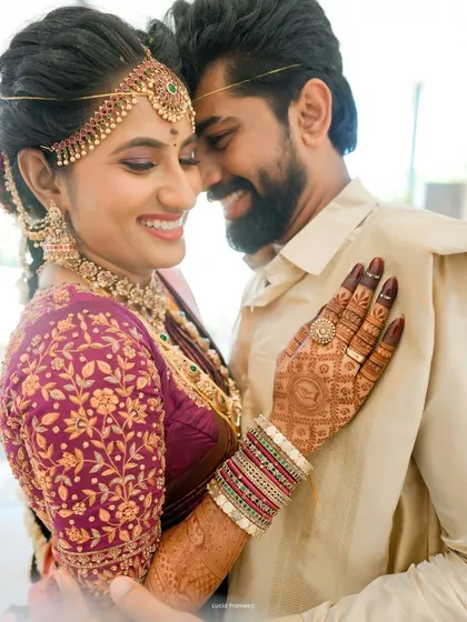 A shared smile that lights up the frame. This close-up from a South Indian wedding highlights the intricate henna and the couple's beautiful bond, showcasing our eye for both detail and emotion.