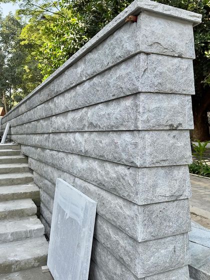 A corner of a stone wall being built, showing the thickness and weight of the material.