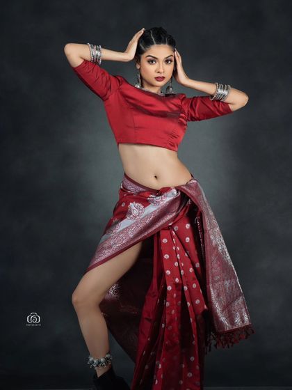 A powerful pose in a red fusion saree look. The image is a great example of how I blend traditional aesthetics with a modern, edgy sensibility in my studio work.