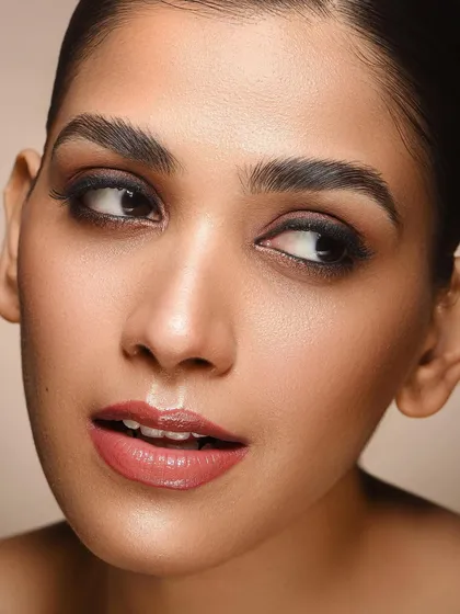 This portrait showcases a classic smokey eye with a modern twist. The lighting is soft and flattering, emphasizing the smooth texture of the skin and the subtle gradients in the eyeshadow. It's a versatile look for any beauty portfolio.