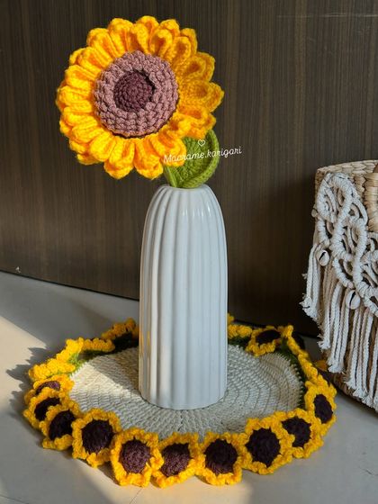 A single crochet sunflower stem placed in a vase on top of our sunflower table mat, creating a cohesive and sunny decorative theme.