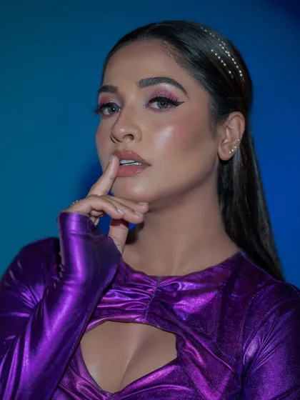A close-up of the high-fashion makeup, with a sharp winged liner and glossy skin.