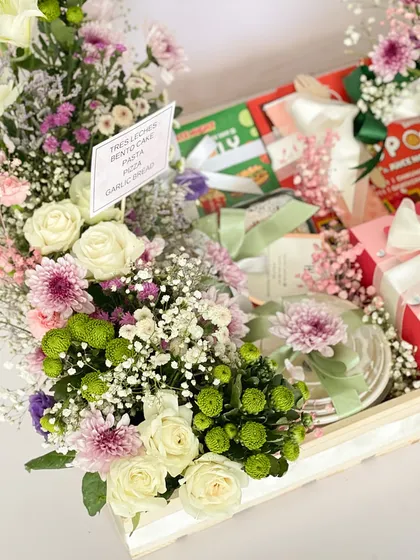 A close-up of the anniversary hamper, showing the beautiful mix of fresh flowers and gourmet treats. The personalized card adds a sentimental touch.