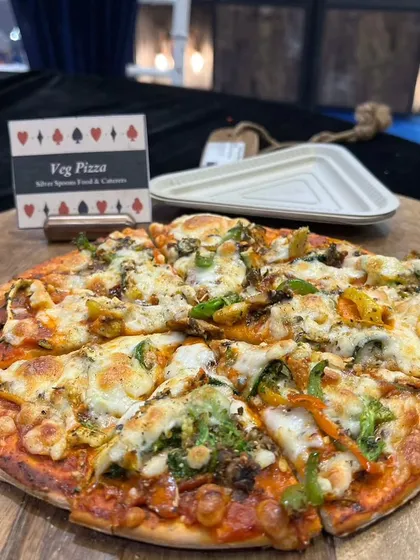 A freshly baked vegetable pizza served on a wooden board. This offering shows my culinary versatility, providing familiar comfort food alongside more traditional or exotic options.