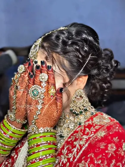 I love this shot because it captures everything. The intricate bridal mehndi, the beautiful jewelry, and the classic bridal hair updo all come together. It shows how every detail is considered to create a cohesive and stunning final look for your big day.