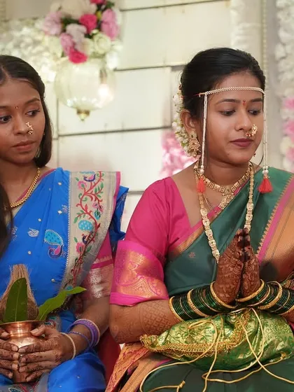The bride during a puja ceremony, showcasing her serene and traditional look. The makeup is subtle, with a focus on clean skin and defined features.