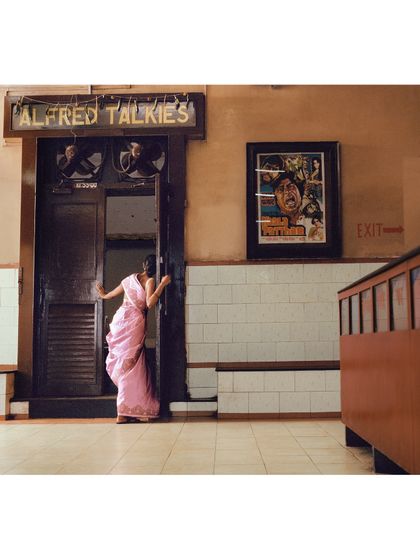Peeking into the theater, this shot captures a moment of curiosity and wonder. The setting of Alfred Talkies in Mumbai was crucial for building this film-centric narrative.