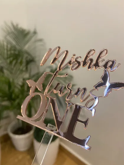 Another view of the "Mishka Turns ONE" topper, showing how the butterflies are integrated into the design for a unique touch.