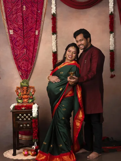 A beautiful couple's portrait in a traditional South Indian style. The green and red saree is vibrant and stunning.