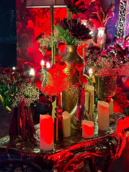 This masquerade-themed party was drenched in dramatic red lighting, with intricate floral centerpieces, candelabras, and even a mirrored mannequin adding to the mysterious and glamorous vibe.