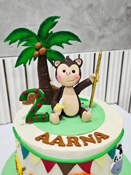 Close-up of the adorable monkey topper with a banana and a number 2 candle.