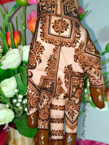 This design looks so beautiful against the floral background. The contrast of the dark henna and the soft flowers is lovely.