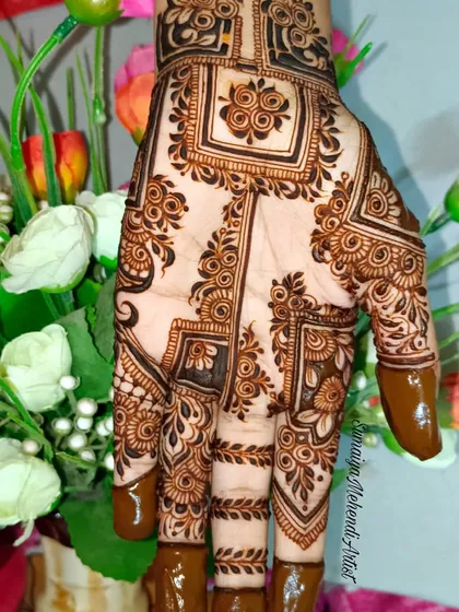 This design looks so beautiful against the floral background. The contrast of the dark henna and the soft flowers is lovely.