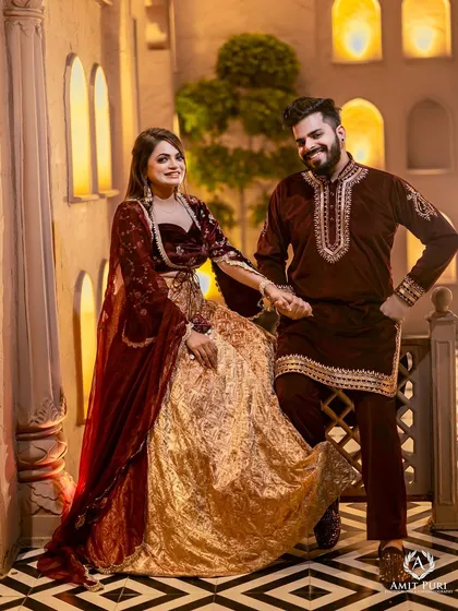A regal portrait of the couple in rich, coordinated velvet outfits. The palace-like setting and their confident poses create an image of pure elegance and grandeur.