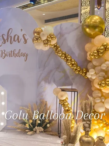 A close-up of the elegant 70th birthday decor, showing the custom "Asha's 70 Birthday" text on the backdrop.