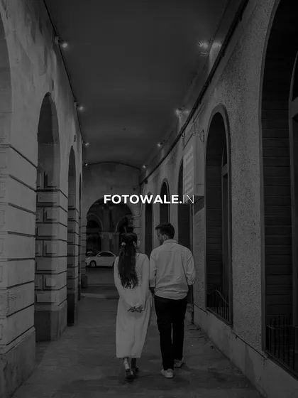 A timeless black and white photo of the couple walking hand-in-hand through a classic Mumbai alleyway. This shot has a beautiful, old-world cinematic feel, focusing on their journey forward together.