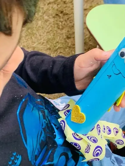 It's all in the details. A close-up of a young creator adding the finishing touches to a craft project, showing the focus and joy that comes from making something with your own hands.