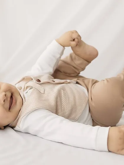 A playful shot of the baby grabbing his feet, a classic 6-month-old move!