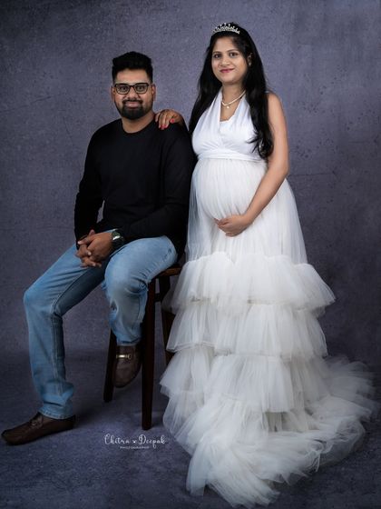 A beautiful formal portrait. The mom-to-be in her white gown and tiara looks like a princess next to her partner.