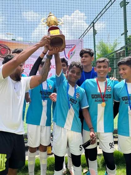 The team celebrating a win, lifting their star defender and the trophy high. This is what teamwork looks like.