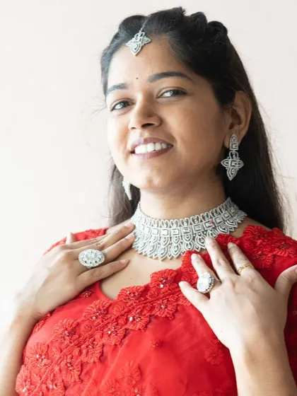 A happy client looking radiant in our silver-plated AD choker set. She has paired it with a red saree, creating a classic and glamorous look for her event.