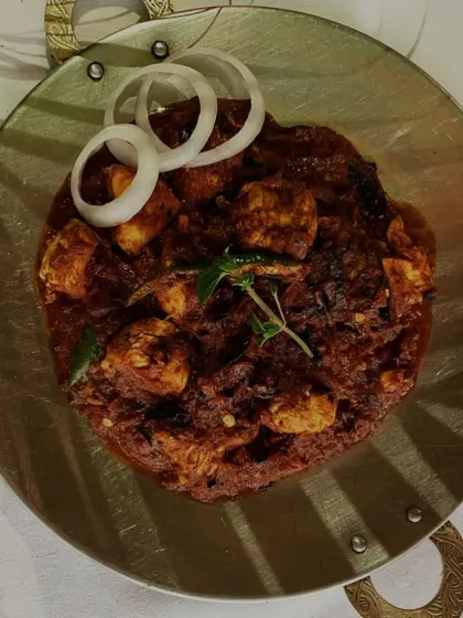 This close-up of our Chicken Tava highlights the rich, dark masala clinging to the tender chicken pieces, promising a dish full of robust and spicy flavors.