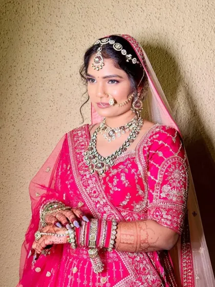 A beautiful bride looking serene and happy on her wedding day. Her choice of a heavy kundan set with a matching matha patti and nath completes her traditional pink bridal look perfectly.