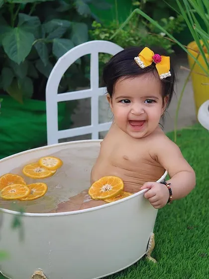 A refreshing orange-slice bath in the garden! This outdoor half-birthday session is a perfect way to cool down in the summer and capture some incredibly happy and splashy photos.