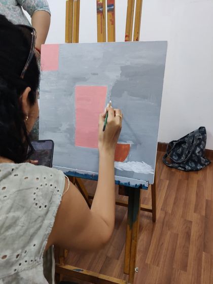 This series captures an adult student working on two different acrylic paintings, one a floral doorway and the other an abstract piece, showing the variety of styles we teach.