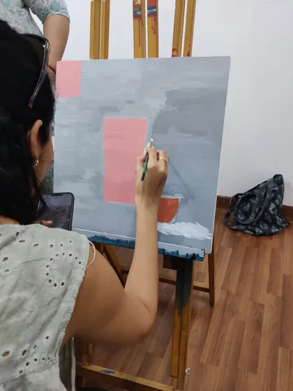 This series captures an adult student working on two different acrylic paintings, one a floral doorway and the other an abstract piece, showing the variety of styles we teach.