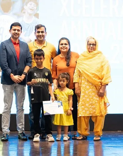 A whole family on stage to celebrate their young player's award at the Xcelerate Annual Day.