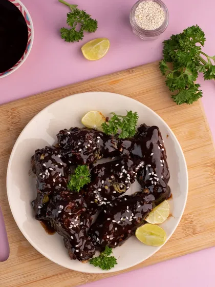 A plate of saucy BBQ chicken wings we shot for Flying Crust. The focus is on the glossy sauce and tender meat, making it a mouth-watering image for any menu.