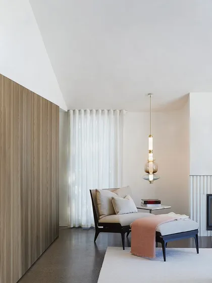 A single Luna Kaleido pendant adds a touch of color and sculptural form to a quiet reading corner, providing both functional light and aesthetic pleasure.