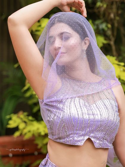 A designer shoot for a modern lavender lehenga. The images were taken in a lush garden, with the purple flowers complementing the color of the outfit, creating a soft and romantic fashion story.