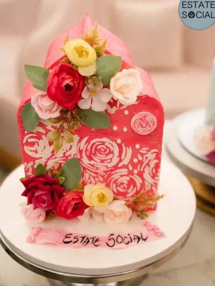 A close-up of a beautiful pink floral cake from the Estate Social event, created by a fellow baker.