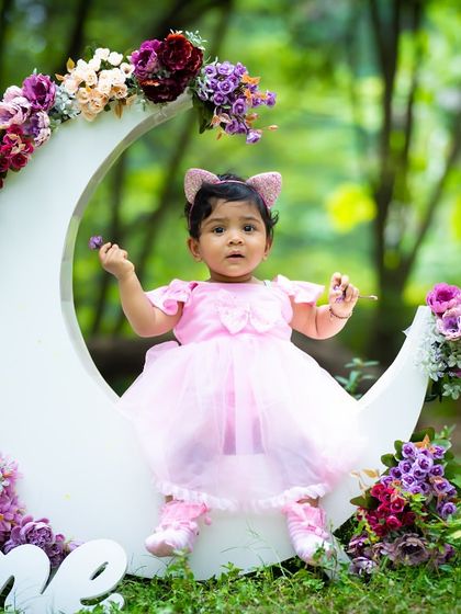 A full view of the outdoor moon prop setup, complete with a "One" sign to celebrate a first birthday in an enchanting way.
