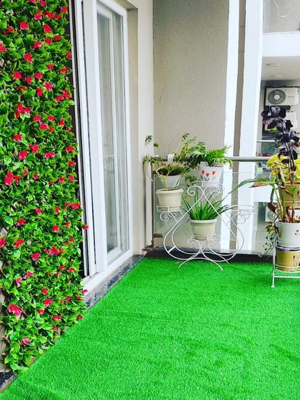 This small apartment balcony now feels like a garden with artificial grass and a floor to ceiling vertical plant wall. It's a great way to add greenery without sacrificing space.