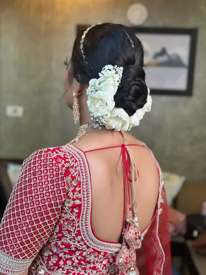 A complete view of the elegant white floral bun, showcasing its perfect shape and placement. This is a go-to style for brides seeking a look of pure grace and sophistication.