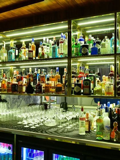 A wider view of our well-stocked bar, showcasing the extensive selection of spirits we offer for crafting the perfect cocktail for you.