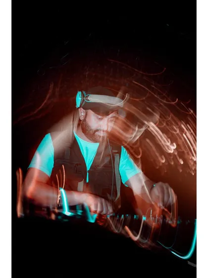 A long exposure shot capturing the motion and energy behind the decks. DJing is a dynamic performance, and this image shows the constant movement and focus that goes into mixing the perfect set.