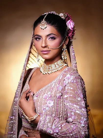 Meet a stunning bride, brought to life with elegant makeup. This look in a pastel purple lehenga features beautiful pink and purple eyeshadow and a soft, glowing complexion.