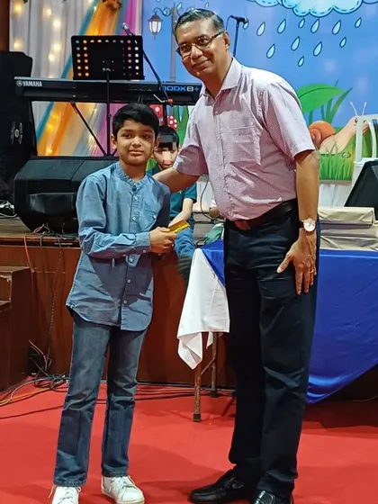 Rhys Pais of ShuttleCraze being awarded for his silver medal performance at the BAMU district championship by the Kanara Catholic Association.