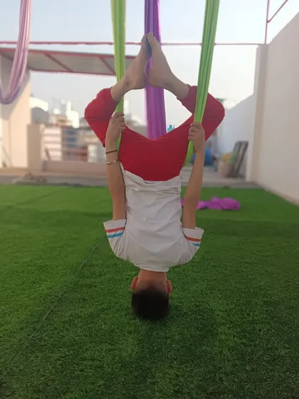 Aerial yoga is a super fun activity for kids. This inverted Baddha Konasana or butterfly pose is great for the hips and is very relaxing.