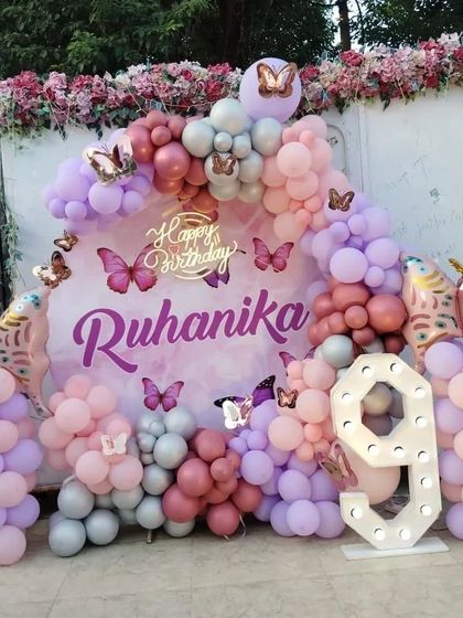 An outdoor butterfly-themed setup for a 9th birthday. I used a mix of pink, purple, and silver balloons, along with large butterfly foil balloons and a light-up number, to create a beautiful party space.