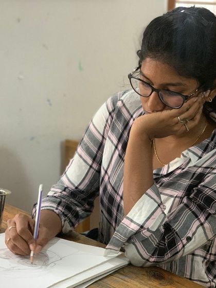 Lost in thought, a student plans her next sketch. Our classroom is a place where you can take your time, think through your ideas, and let your creativity unfold naturally.