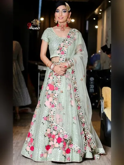 A client looking radiant in a mint green lehenga with colorful floral embroidery. This is a wonderful rental option for a spring or summer wedding event.