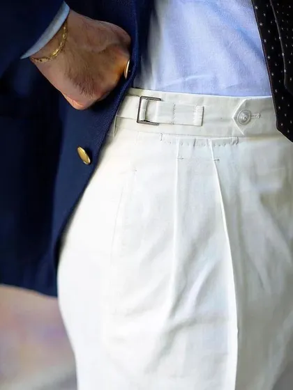 The clean lines of our custom white trousers, featuring side adjusters for a perfect fit. They are a versatile staple that pairs well with any blazer or shirt.