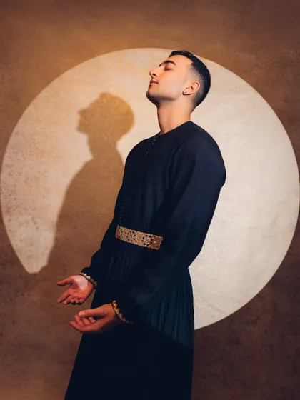 A moment of surrender and expression. The spotlight creates a dramatic shadow, adding to the "Sitar Sorcerer" vibe.
