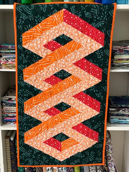 This wall hanging uses clever fabric placement to create a mind-bending 3D illusion.